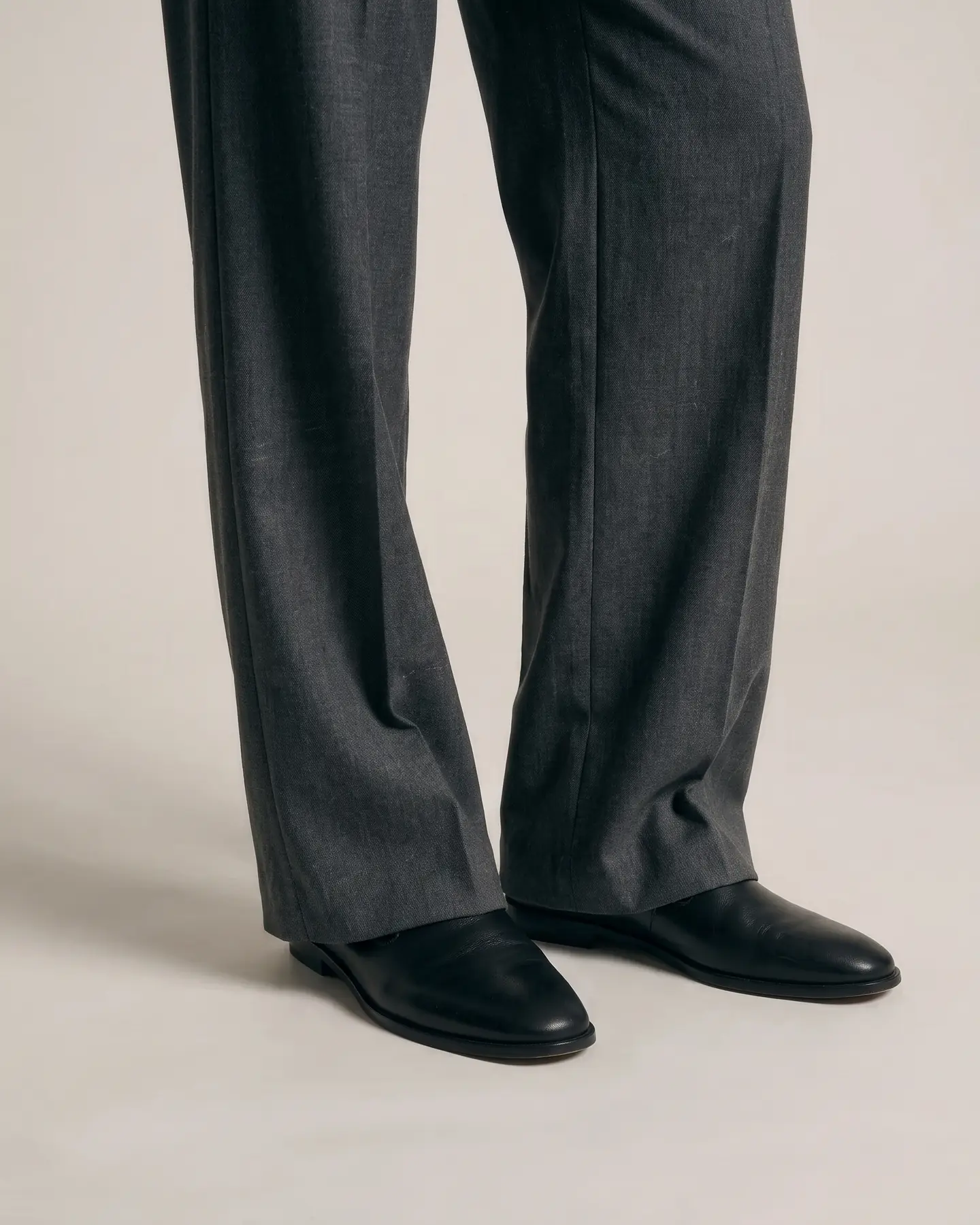 A close view of the hem where the trouser breaks over the shoe